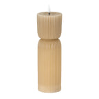 Tall beige LED candle on a white background, with fine vertical ribs, a pinched waist and a white flame-shaped element above a recessed top.