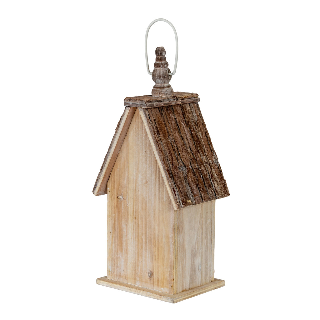 Rear three-quarter view of the birdhouse, showing the plain pale washed back and side, rough dark-brown roof and turned top finial.