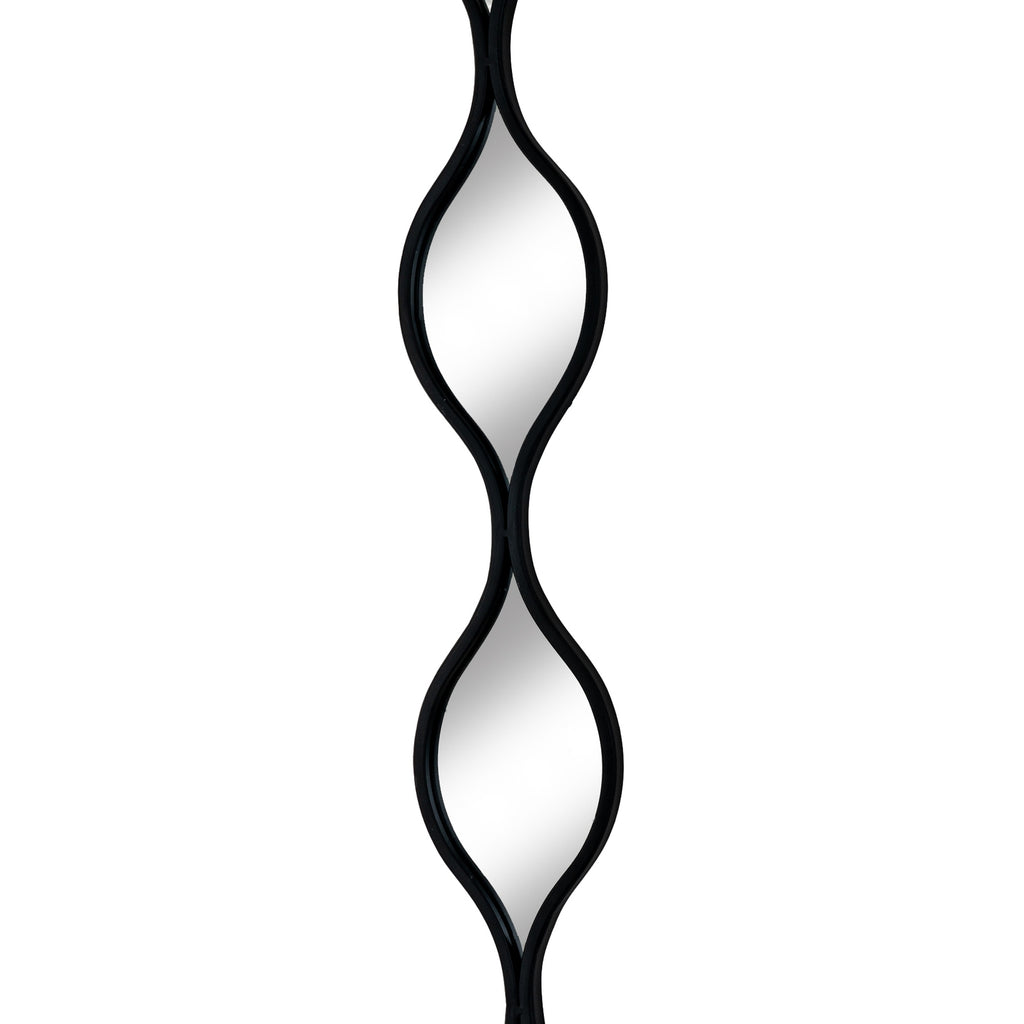 Close front view of two leaf-shaped mirrored sections and the narrow crossing point where their black frames meet.