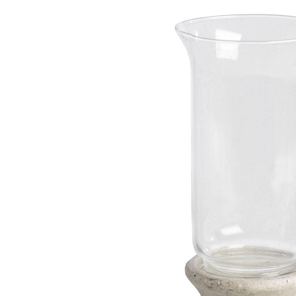 Close-up of the lantern's clear sleeve, showing its outward-curving rim, reflective sides and the rounded top of the textured pedestal.