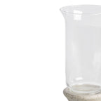 Close-up of the lantern's clear sleeve, showing its outward-curving rim, reflective sides and the rounded top of the textured pedestal.