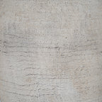 Detail of the vase's granular cream surface with tiny dark flecks and closely spaced horizontal scrape-like lines.