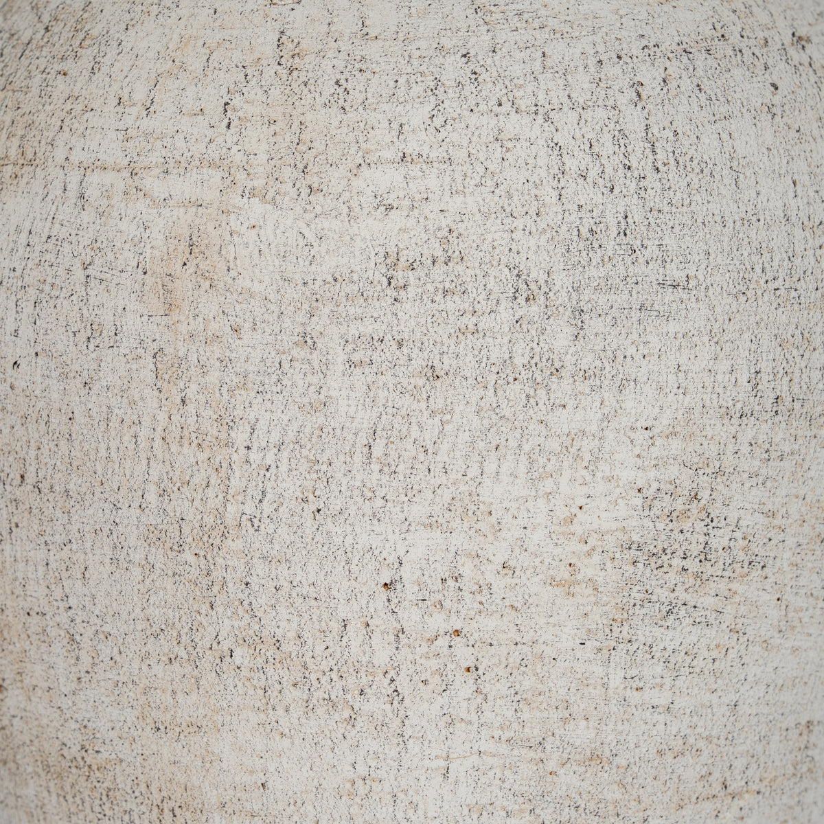 Detail of the vase's granular cream surface, showing scattered dark flecks and irregular horizontal and vertical marks.