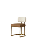 Three-quarter front view of an armless dining chair with a pale textured backrest, cognac seat and brass-toned open frame with a curved base, on white.