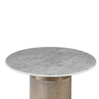 Angled view across the round marble tabletop, showing grey veining and a rounded edge above the gold pedestal.