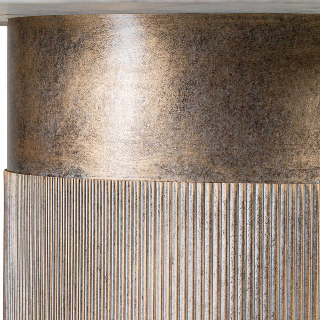Close-up beneath the marble top, showing the mottled gold finish on the smooth upper band and fine fluting below.