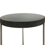 Detail of a round black-tinted mirrored tabletop and its textured fluted rim, with the upper sections of the legs below.