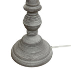 Close-up of the lamp's grey stepped foot and rounded lower stem, showing fine pale surface lines and a white flex exiting at the side.