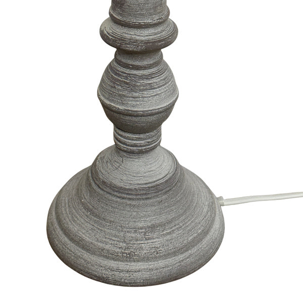 Close-up of the lamp's grey stepped foot and rounded lower stem, showing fine pale surface lines and a white flex exiting at the side.