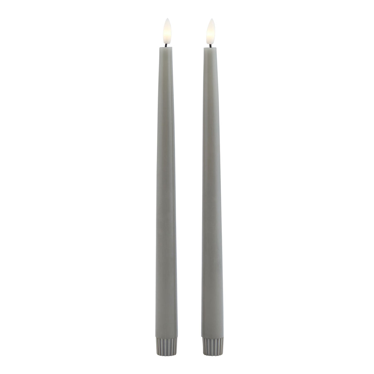 Full-length view of two grey dinner candles with pale yellow centres visible in their white tips and fluted sleeves at the bases.