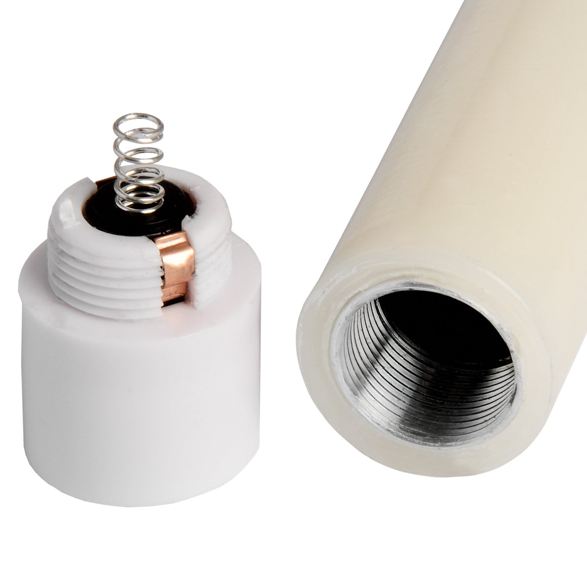Close-up of an ivory candle with its white base cap removed, showing a silver-coloured coil, a copper-coloured strip and the threaded cavity in the body.