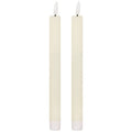 Two matching slender ivory dinner candles with white flame-shaped tips on dark posts and ribbed white lower sleeves, against a white background.