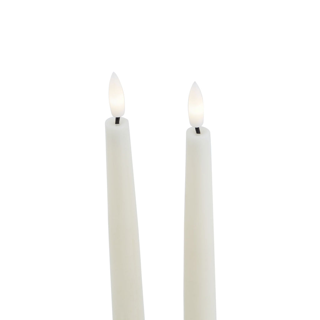Close-up of the upper portions of two pale LED candles, showing white flame-shaped inserts with warm white centres above short dark stems.