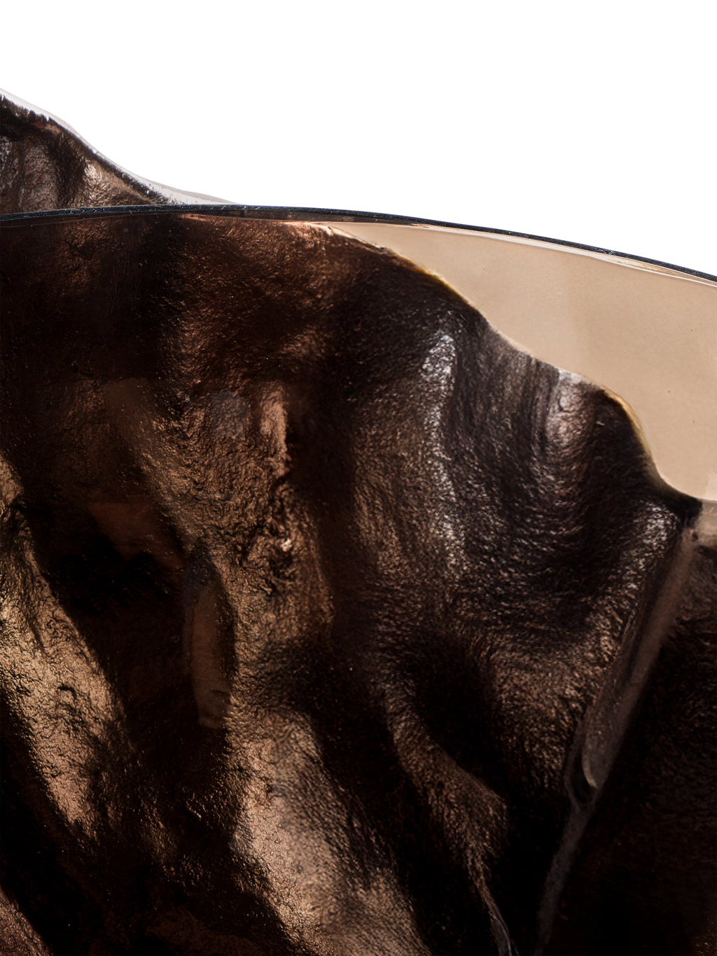 Close-up of the smoked glass rim crossing in front of the dark, textured folds of the metal surround.