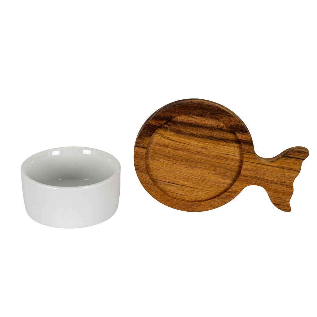 Close view of a straight-sided glossy white bowl beside a brown fish-shaped tray, showing the recessed circular seat, visible grain and forked tail.