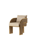 Three-quarter front view of a beige dining armchair with a back cushion, curved gold-edged arms and channel-stitched panels extending down the broad legs.