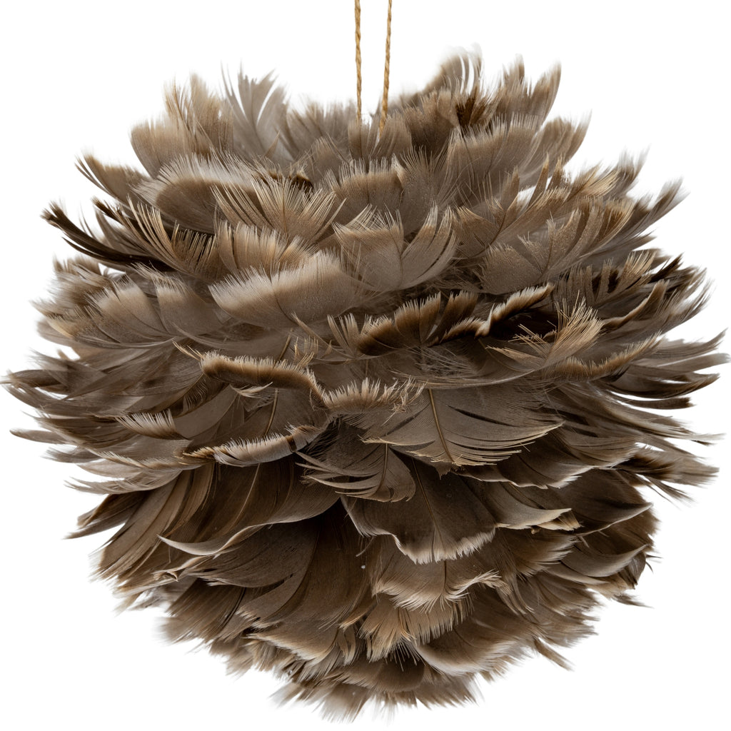Close-up of overlapping grey-brown and warm-brown feather-like elements, showing fine fringed edges and curled tips on the hanging ball.