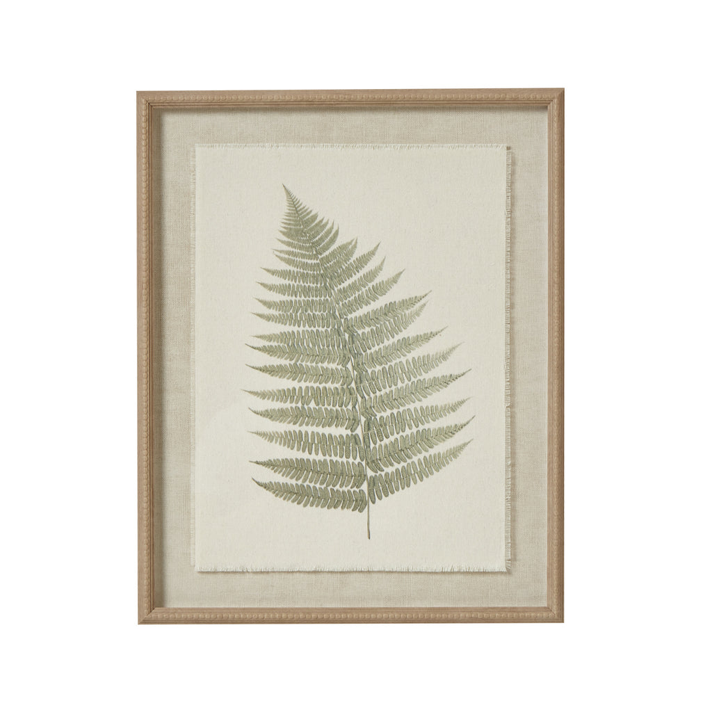 Front view of a single green fern frond on pale textured backing within a tan beaded frame.