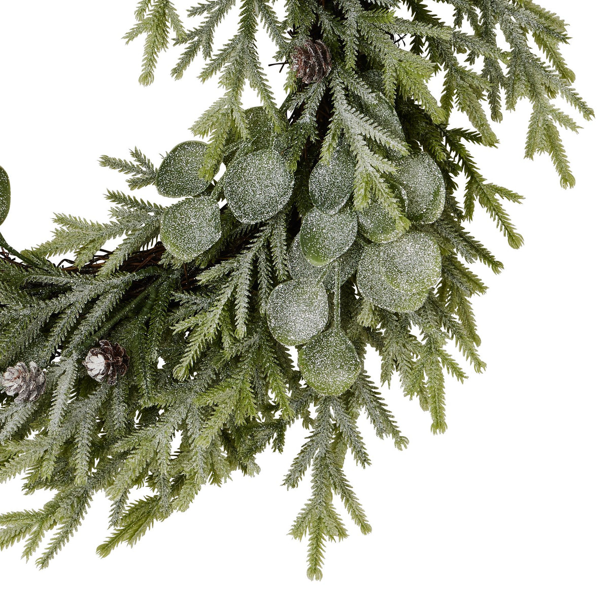 Close-up of frosted rounded leaves and fine green sprigs, with brown pinecones and part of the twig-like wreath ring visible.