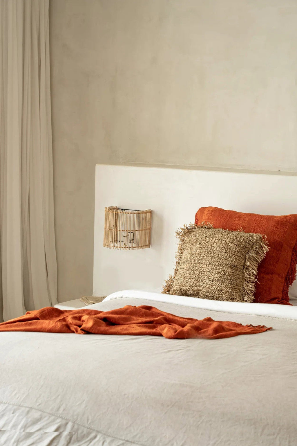 Gigi Rattan Wall Applique – Natural, Small – styled above a bed