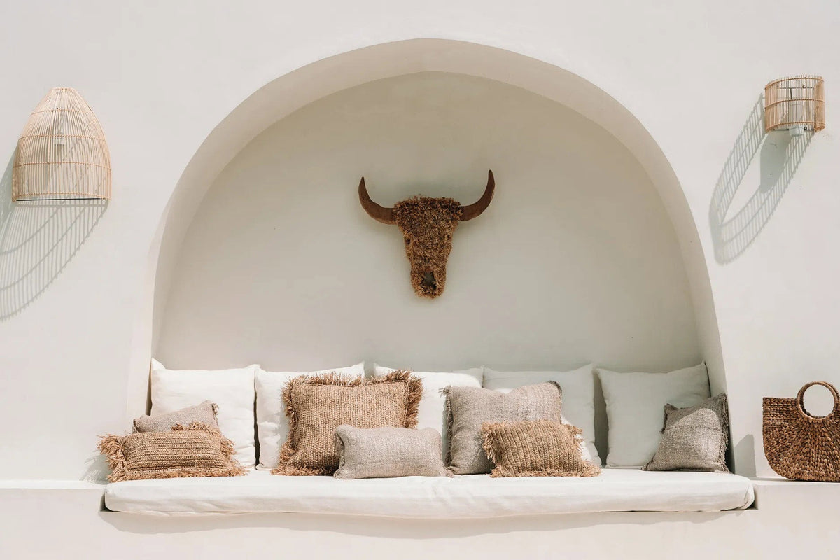 Gigi Rattan Wall Applique – Natural, Small – paired wall lights beside an arched seating alcove