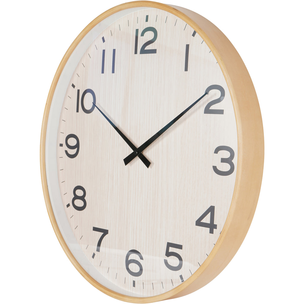Angled view of the wall clock showing the depth of its natural-toned frame and the glass over its numbered dial.