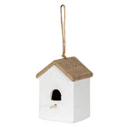 Three-quarter view of an off-white birdhouse-shaped ornament with a brown pitched roof, arched opening, pale perch and long tan rope loop.