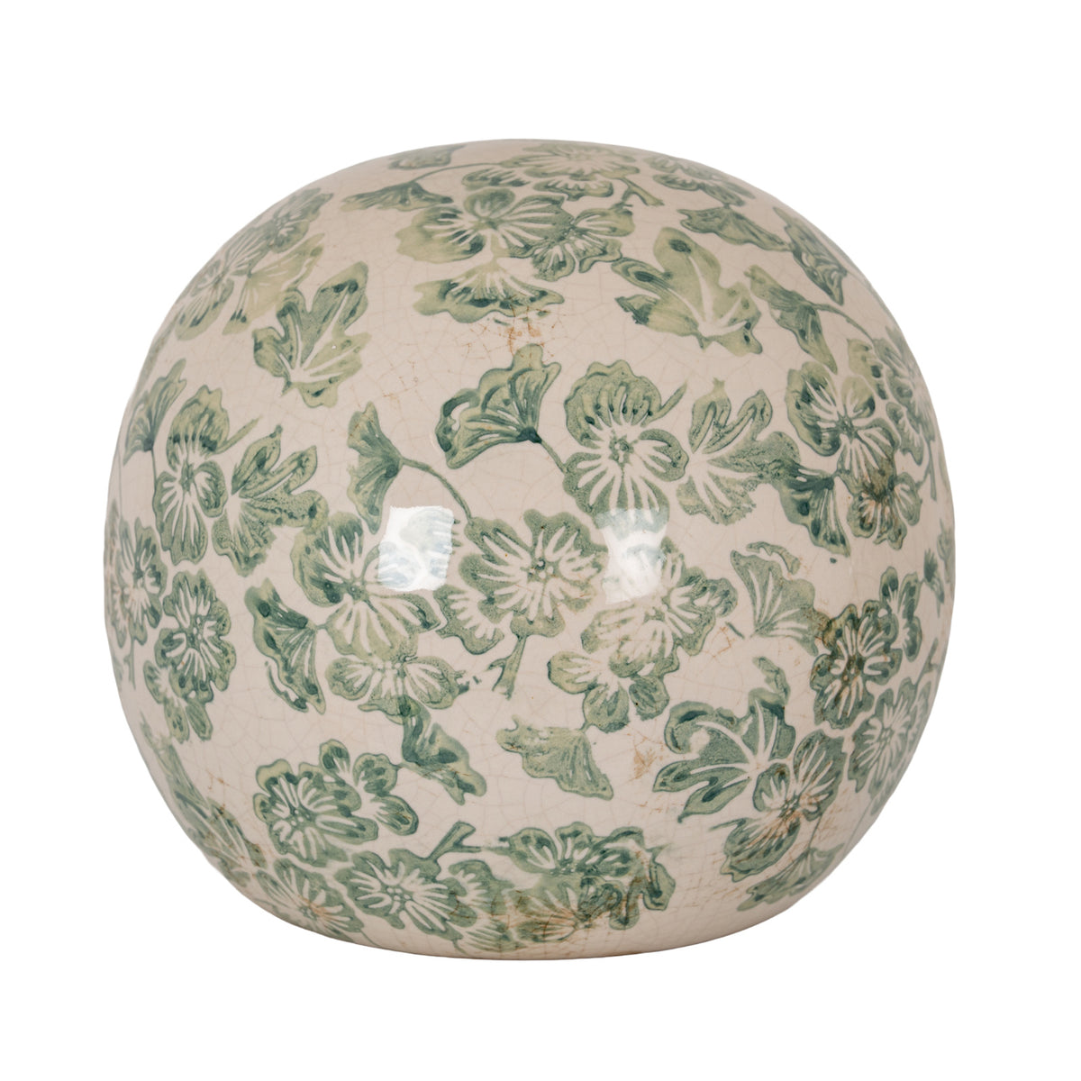 Cream decorative ball covered in green flowers and leaves, showing fine crackle lines and bright surface reflections against a white background.