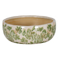 Shallow round planter with green flowers and leaves on a cream crackle finish, viewed from above to show the tan interior.