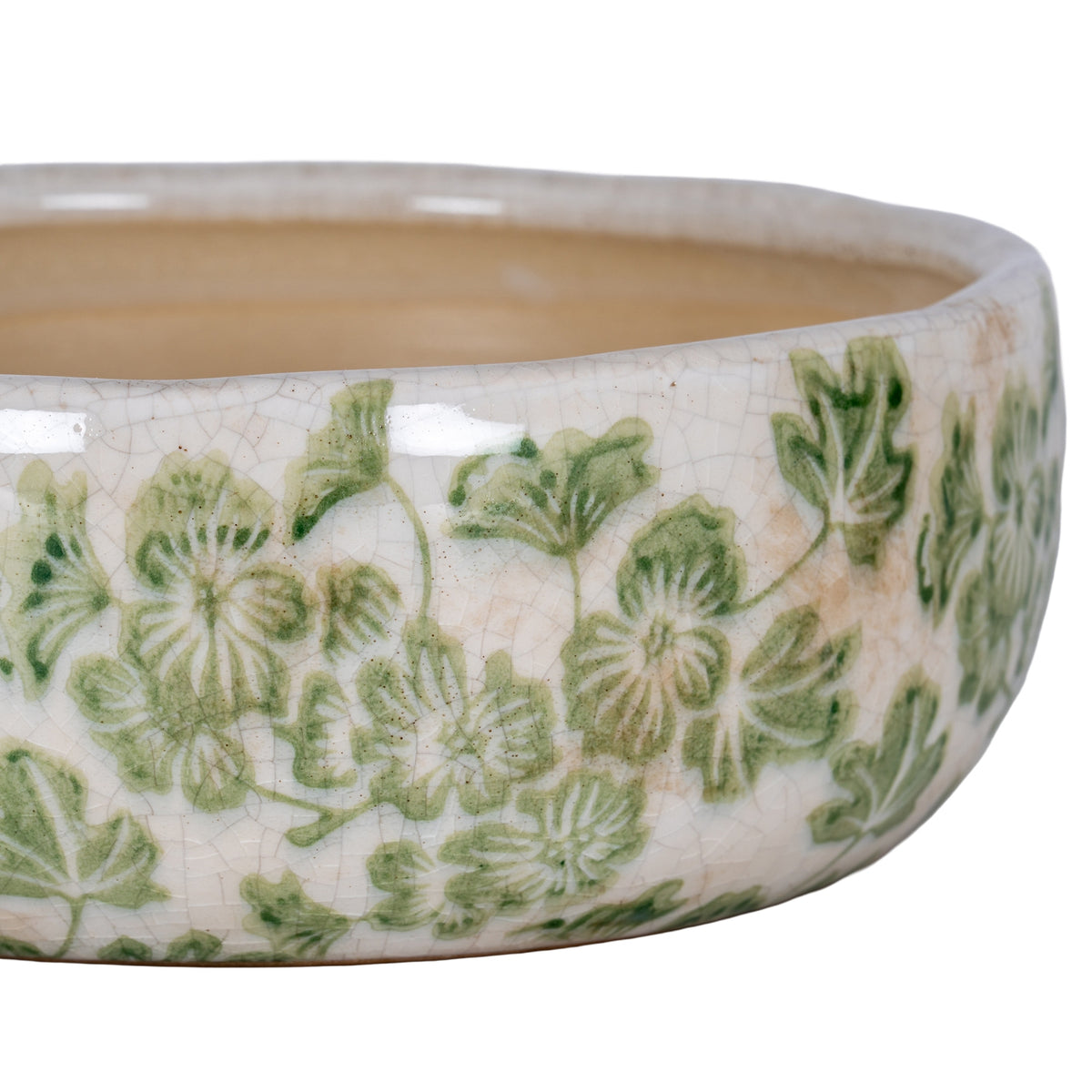 Close-up of the planter’s glossy curved side and rim, showing green floral details, fine crackle lines and scattered tan markings.