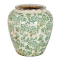 Rounded cream-white vase with green flowers and leaves, gently tapering sides and dark distressed detailing at the rim and base.