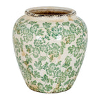 Rounded cream-white vase with green flowers and leaves, gently tapering sides and dark distressed detailing at the rim and base.