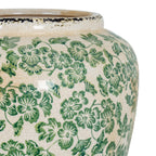 Close-up of green floral and leaf motifs on the vase's curved shoulder, showing fine crackling, glossy reflections and a dark distressed rim.