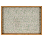 Overhead view of the Green Leafbase Tray, showing scattered green leaves across the pale base within a rectangular wood-tone rim.