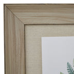 Close-up of the upper left mitred frame corner, showing pale grain-like markings, dark edging and the beige mount's woven appearance.