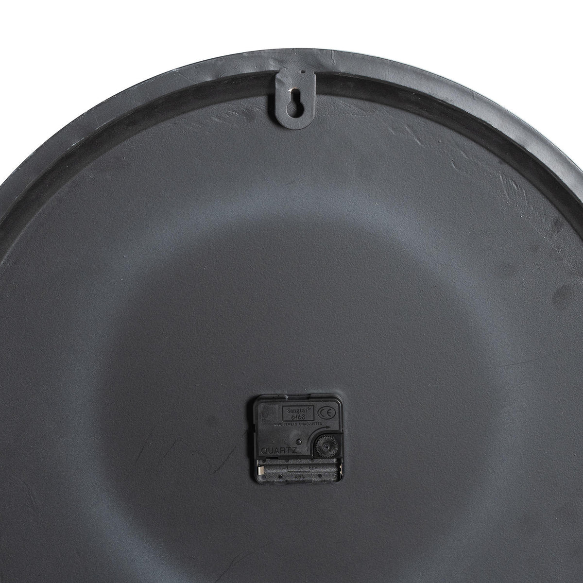 Rear view of the clock showing its dark back, quartz mechanism and keyhole hanging tab.