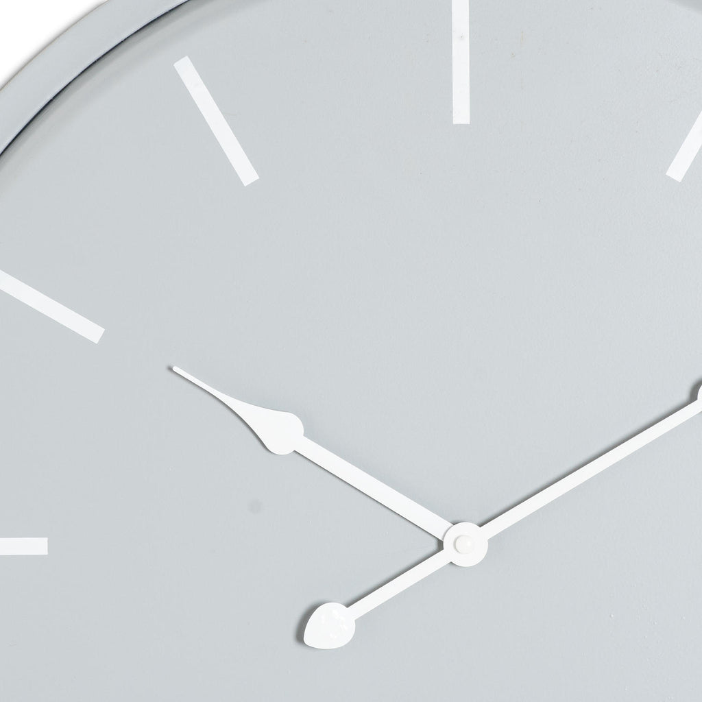 Close-up of the grey clock face showing white baton markers and the curved detail on the white hands.