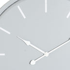 Close-up of the grey clock face showing white baton markers and the curved detail on the white hands.
