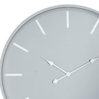 Close-up of the grey clock face showing white baton markers and decorative pointed hands around the central pivot.