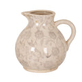 Cream decorative jug with grey flowers and scrolling stems, fine brown crackle-like lines, a pouring lip on the left and a thick loop handle on the right.