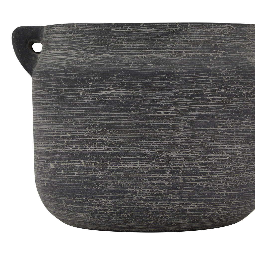 Close-up of the grey vase body, showing closely spaced pale lines, scattered surface marks and one small handle on the left.