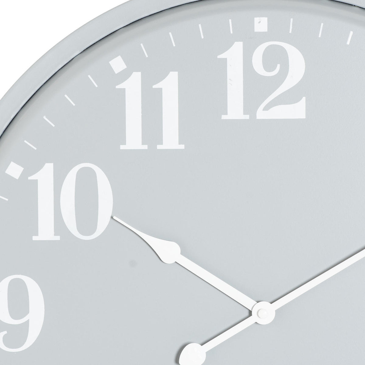 Close-up of the grey clock face showing white numerals 10, 11 and 12, minute marks and the shaped white hands.