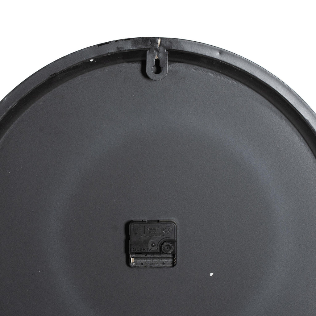 Rear view of the clock showing its dark circular back, central black movement and keyhole-shaped hanging tab at the top.