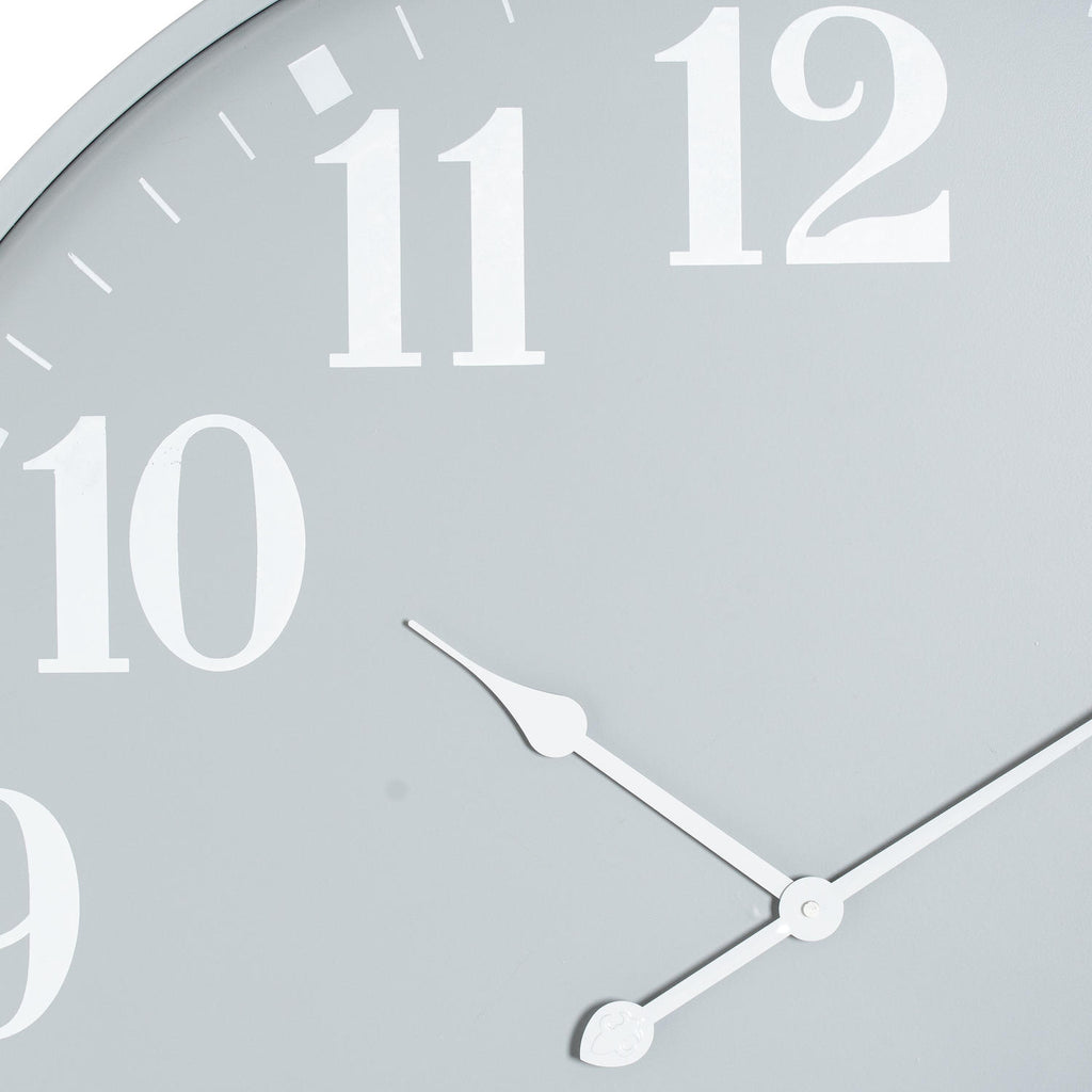 Close-up of the grey clock face showing the white 10, 11 and 12 numerals, fine minute marks and shaped white hands.