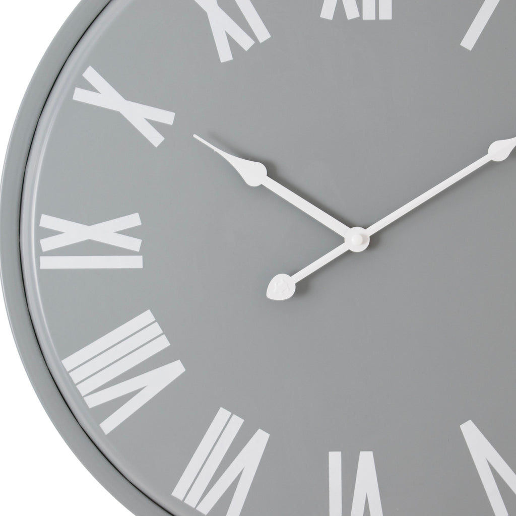 Close-up of the grey clock face showing the shaped white hands, central hub and large white Roman numerals.