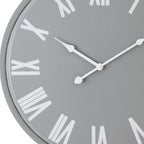 Close-up of the grey clock face showing the shaped white hands, central hub and large white Roman numerals.