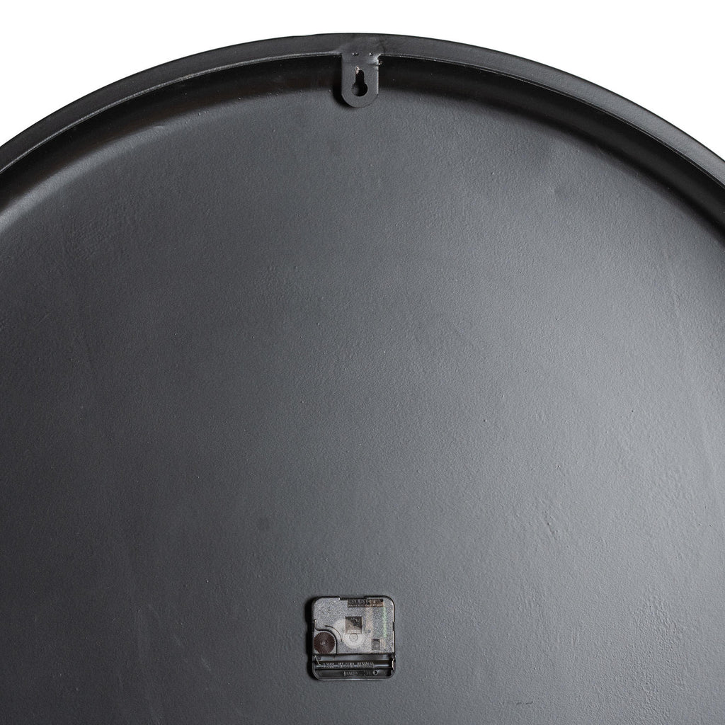 Rear view of the clock showing its dark circular back, a keyhole hanging tab at the top and the movement near the lower centre.