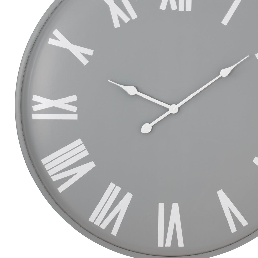 Close-up of the grey clock face showing the shaped white hands and large Roman numerals along the left and lower edge.