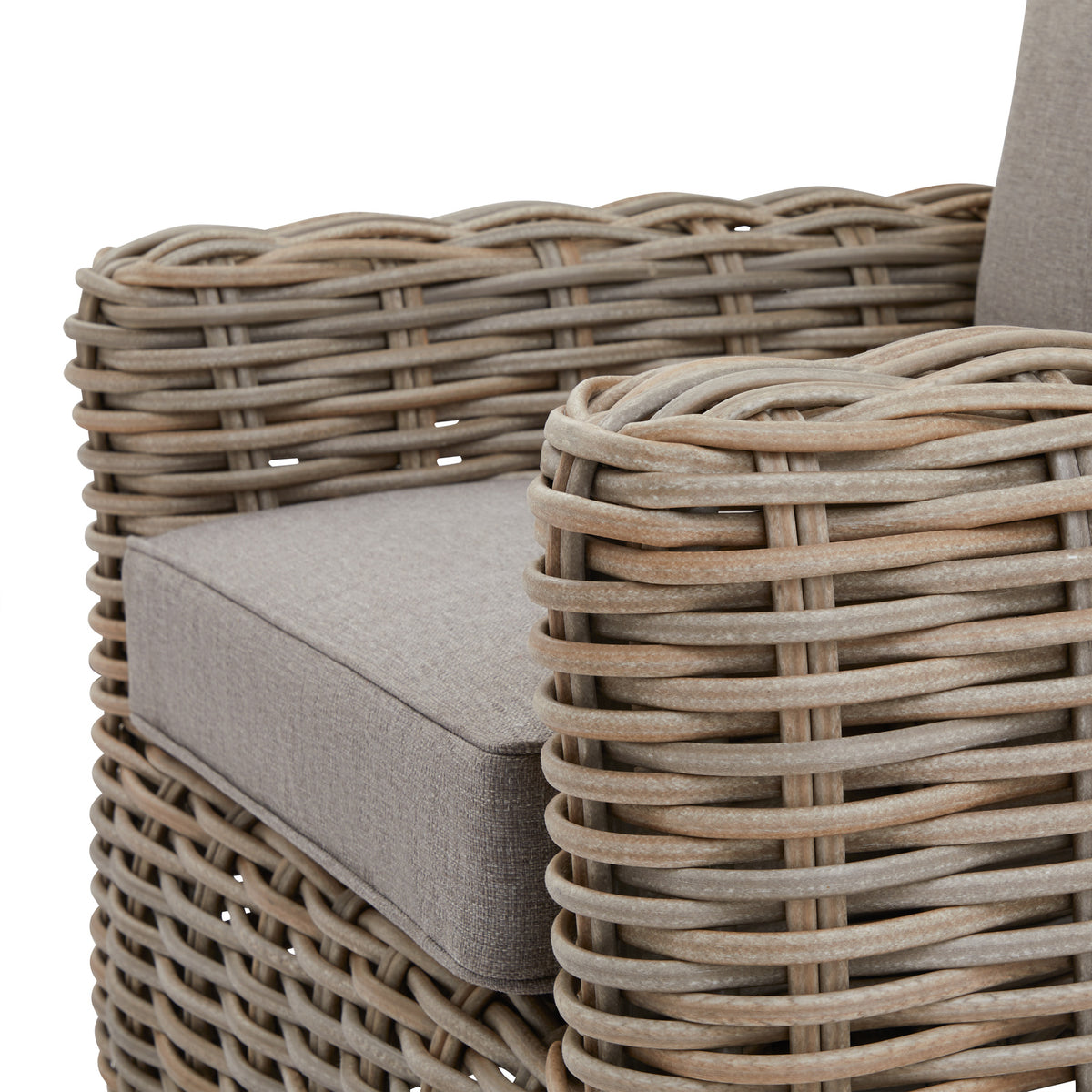 Close-up of the mottled grey weave around an armchair's rounded arm, beside the fine texture and edged seam of its pale grey seat cushion.