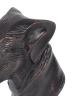 Close-up of the folded ear and textured cheek and neck, with bronze-toned highlights against the black finish.